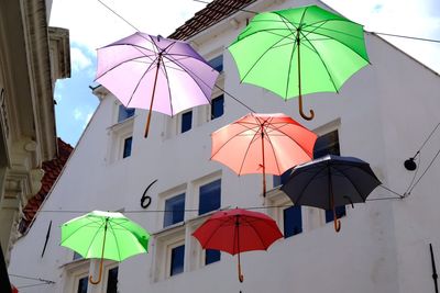 Low angle view of umbrellas against buildings in city