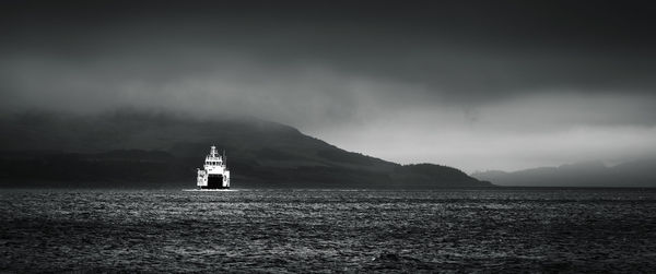 Lighthouse by sea against sky