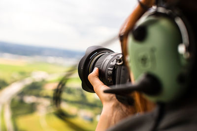 Cropped image of person photographing through camera