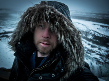 Portrait of man standing outdoors during winter