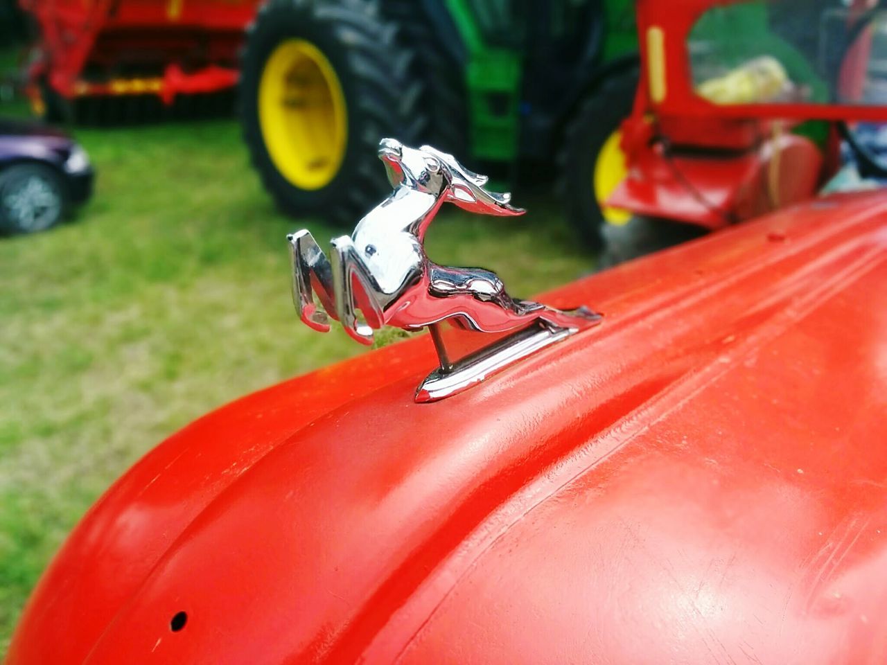 transportation, land vehicle, red, mode of transport, car, focus on foreground, close-up, motorcycle, bicycle, stationary, day, outdoors, toy, part of, motion, grass, selective focus, no people, travel, field