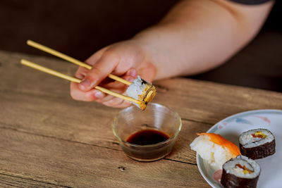 Cropped hand holding sushi
