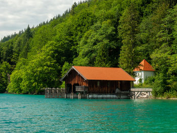 Old wooden dock houses on the lake with typical wooden pier, the walchensee in bavaria germany