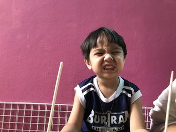 Portrait of a smiling boy against wall