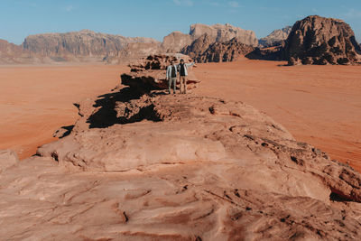 People on rock formations in desert