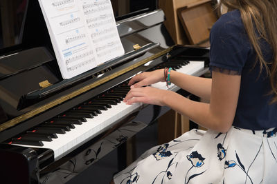 Teenage girl playing the piano in the classroom, music hobby