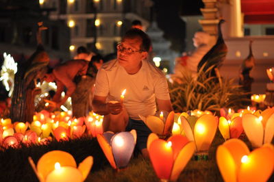 Lit candles on display at night