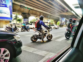 People riding motorcycle on road