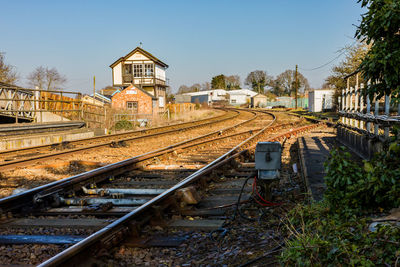 Railroad tracks amidst buildings against clear sky