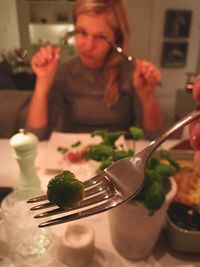 Midsection of woman having food in restaurant