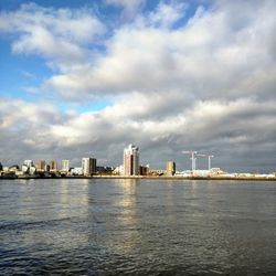 Sea by buildings against sky in city