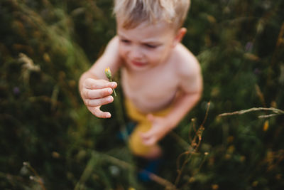 Young male toddler holding a flower