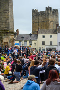 People on street against buildings in city