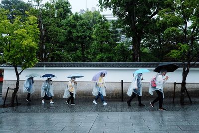 People walking on footpath in rainy season