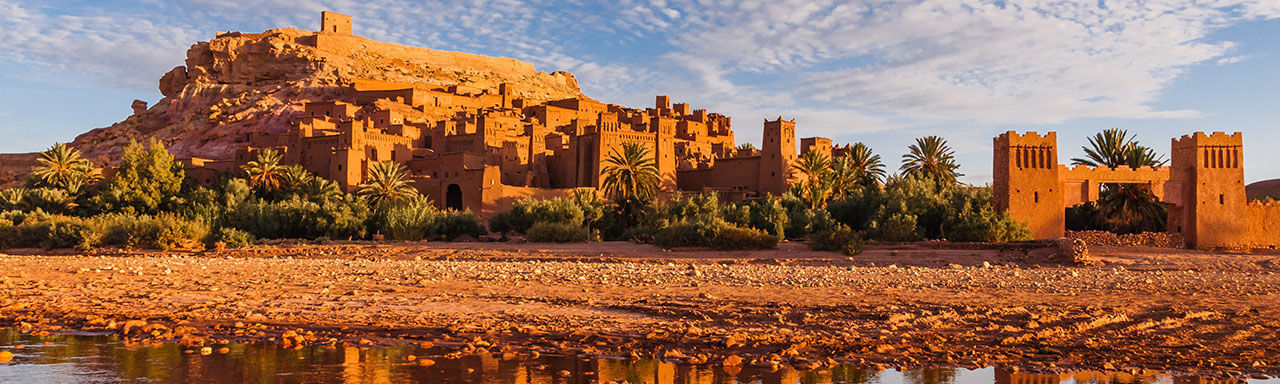 PANORAMIC VIEW OF BUILDINGS AND ROCKS IN WATER