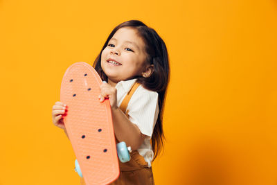 Portrait of young woman against yellow background