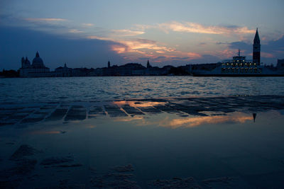 Reflection of buildings in river at sunset