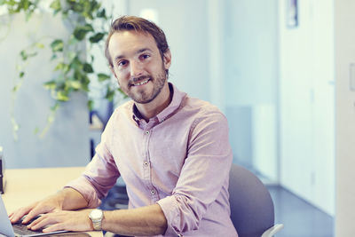 Portrait of smiling man sitting at office