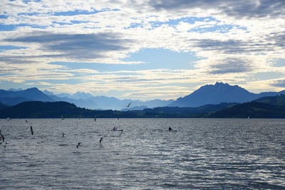 Scenic view of sea and mountains against sky