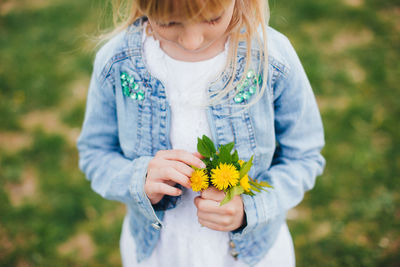 Midsection of woman holding flowering plant