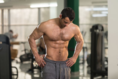 Shirtless man standing in gym