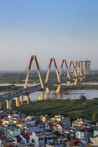 Bridge over river in city against clear sky