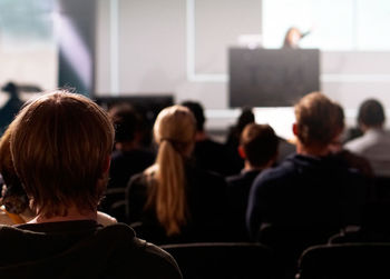 Rear view of students attending lecture in auditorium