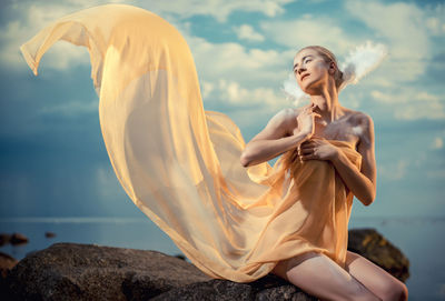 Close-up of young woman against sea