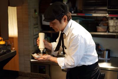 Chef preparing takoyaki in kitchen