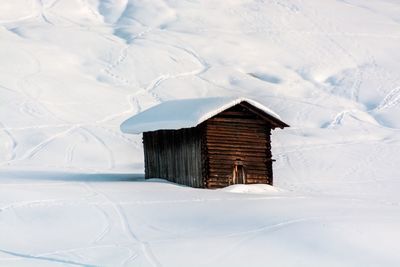 House on snow covered field by building