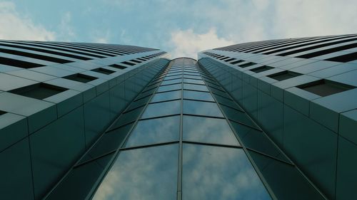 Low angle view of modern building against cloudy sky