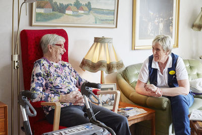 Senior woman talking with nurse in care home