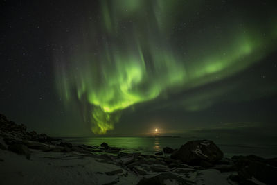 Scenic view of sea against aurora polaris at night