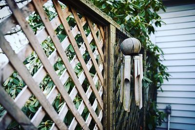 Wooden wind chime hanging on fence at yard