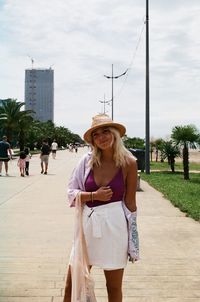 Portrait of young woman standing on road