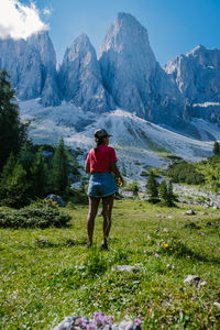 Rear view of man standing on mountain against sky