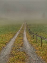 Road amidst field against sky