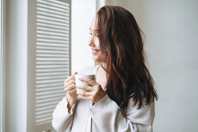 Young woman drinking coffee at home 