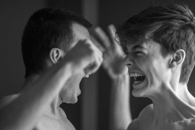 Close-up of young man and boy fighting at home