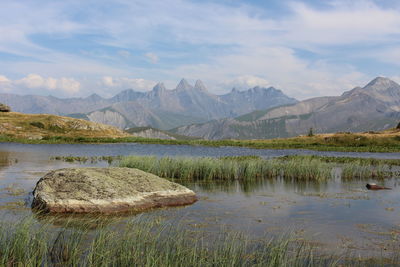 Scenic view of lake by mountains against sky