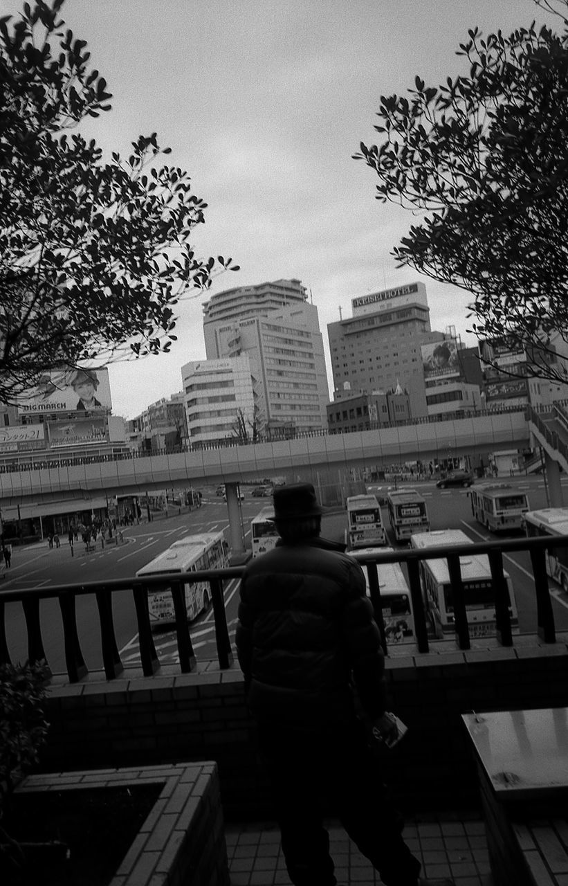 rear view, real people, railing, sitting, men, built structure, full length, one person, architecture, day, adults only, people, outdoors, adult, only men