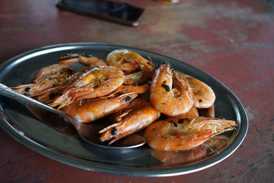 Grilled shrimps served in tin plate on the table