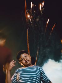 Portrait of happy boy holding toy at night