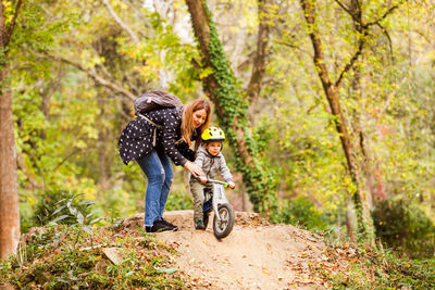 Rear view of people riding motorcycle in forest