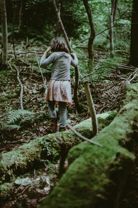 Rear view of woman walking in forest