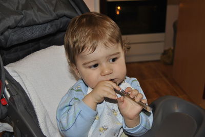 Close-up of cute boy playing with spoon at home