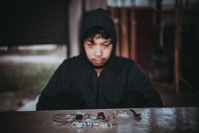 Portrait of young man sitting on table