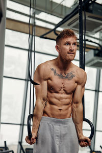 Portrait of young man exercising in gym