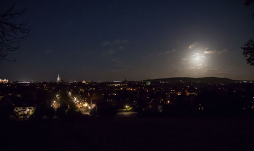 Illuminated cityscape against sky at night