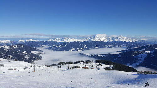 Scenic view of snowcapped mountains against blue sky